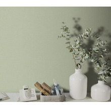 Close-up van een subtiel patroonbehang in een heldere kamer met decoratieve elementen.