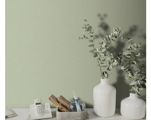 Close-up van een subtiel patroonbehang in een heldere kamer met decoratieve elementen.