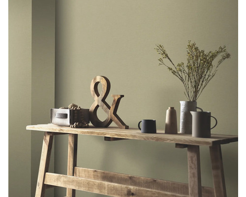 Decoratieve scène op een houten tafel met houten decoratie, droogbloemen in een vaas en keramisch servies voor een gekleurde wand.