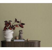 Decoratief behang in de woonkamer met vaas en decoraties op een houten kast.