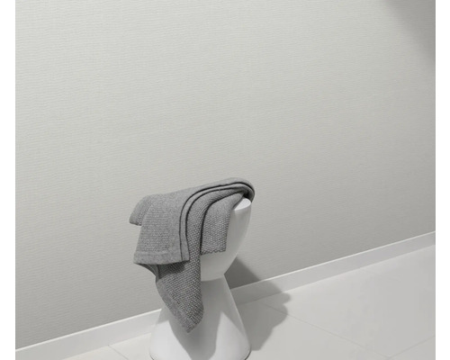 Grijze deken op een witte kruk in een badkamer