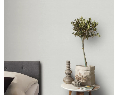 Slaapkamer met bed, bijzettafel, olijfboom en decoratie