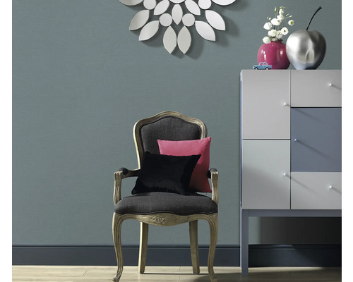 Decoratieve woonkamerambiance met stoel, kussens, ladekast en spiegel