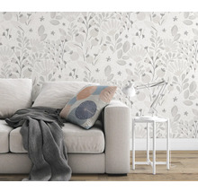 Woonkamer met bank, kussen, deken, tafellamp en bloemenbehang