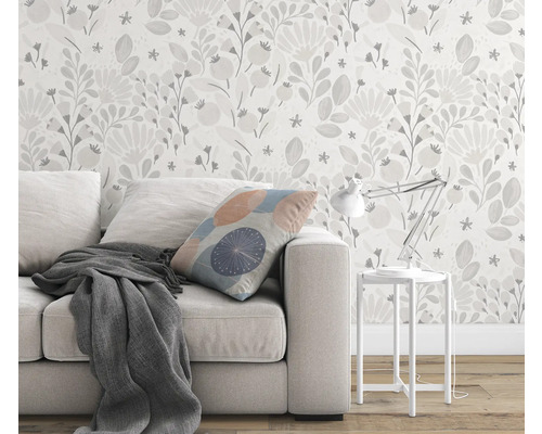 Woonkamer met bank, kussen, deken, tafellamp en bloemenbehang