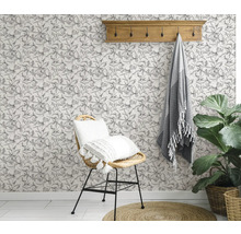 Gedecoreerde kamer met een stoel, een handdoek, een plant en een bloemenbehang