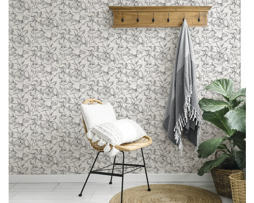 Gedecoreerde kamer met een stoel, een handdoek, een plant en een bloemenbehang