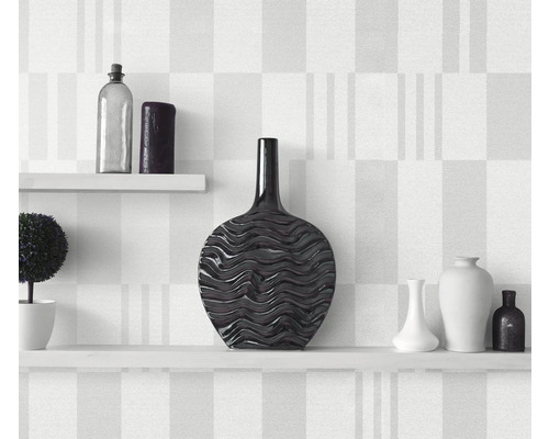 Decoratieve vazen op witte planken voor een muur met patroon