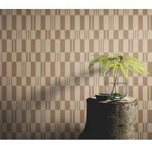 Behang met geometrisch patroon, gecombineerd met een boomstronk als tafel en een plant in een vaas.