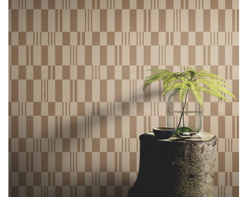 Behang met geometrisch patroon, gecombineerd met een boomstronk als tafel en een plant in een vaas.