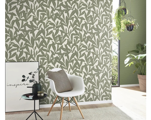 Kamer met behang met bladerenmotief, stoel en decoratie voor een stijlvolle sfeer.
