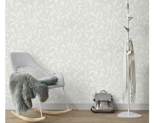 Kamerzicht met behang met bladerpatroon, schommelstoel, kapstok en tas