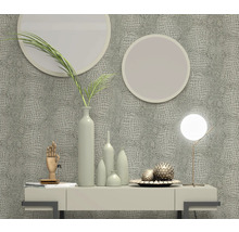 Decoratieve scène met behang in krokodillenleerlook, ronde spiegels, tafellamp en vazen op een dressoir