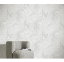 Lichte kamer met bladpatroonbehang en fauteuil