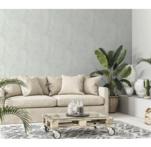 Woonkamer met bank, planten, salontafel en patroonbehang voor een lichte en gezellige sfeer.