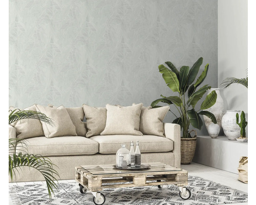 Woonkamer met bank, planten, salontafel en patroonbehang voor een lichte en gezellige sfeer.