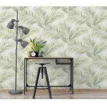 Scene met een vloerlamp, een bureau, een kruk en behang met palmmotief