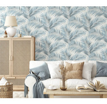 Woonkamer met bank, tafel en kast voor een behang met palmmotief