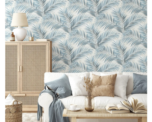 Woonkamer met bank, tafel en kast voor een behang met palmmotief