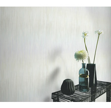 Licht behang met verticaal streepmotief in de woonkamer met bloemenvazen op een tafel