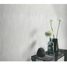 Licht behang met verticaal streepmotief voor een tafel met vazen en bloemen