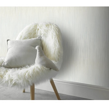 Decoratief interieur met een gestructureerd behang, een met bont beklede stoel en een kussen