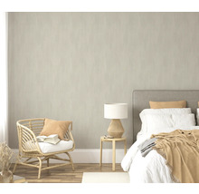 Slaapkamer met bed, bijzettafel, lamp en rotan stoel