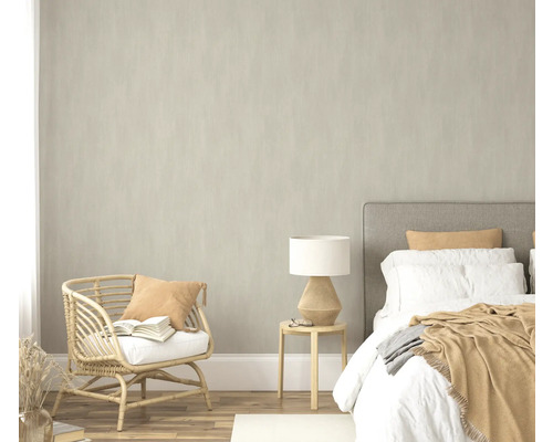 Slaapkamer met bed, bijzettafel, lamp en rotan stoel