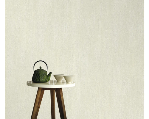 Lichtkleurig vliesbehang met fijne structuur op een tafel met theepot en schalen