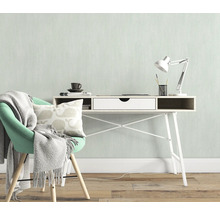 Lichte werkkamer met bureau, bureaulamp, stoel, kussen en deken voor een vriendelijke sfeer.