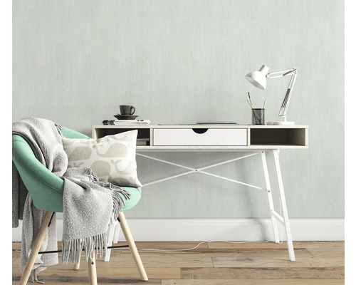 Lichte werkkamer met bureau, bureaulamp, stoel, kussen en deken voor een vriendelijke sfeer.