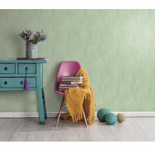 Lichte kamer met mintgroen structuurbehang, commode, stoel, boeken en decoratie