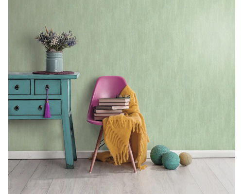 Lichte kamer met mintgroen structuurbehang, commode, stoel, boeken en decoratie