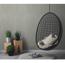 Inrichtingsidee met hangstoel, planten op houten krukjes en tapijt