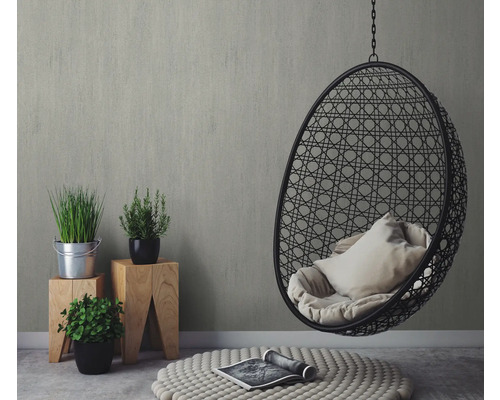 Inrichtingsidee met hangstoel, planten op houten krukjes en tapijt