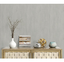 Decoratieve scène met vaas, takken, afbeelding en decoratieve objecten op een houten dressoir voor een grijze wand