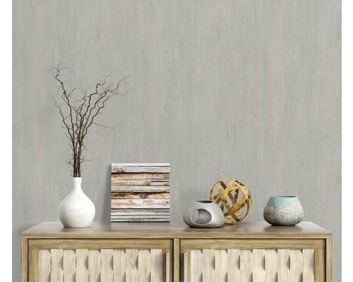 Decoratieve scène met vaas, takken, afbeelding en decoratieve objecten op een houten dressoir voor een grijze wand