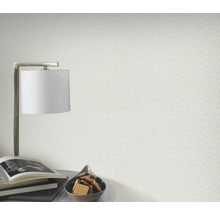 Close-up van een gestructureerd behang in een lichte ruimte met lamp, boeken en gebak