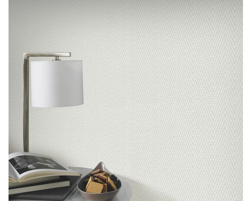 Close-up van een gestructureerd behang in een lichte ruimte met lamp, boeken en gebak