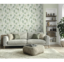 Woonkamer met bank, hocker, vloerkleed, boekenplank en behang met boommotief voor een gezellige sfeer