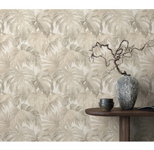 Behang met bladerpatroon achter houten tafel met decoratie