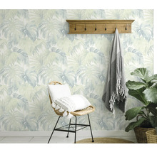 Decoratieve kamer met behang met bladerenmotief, kapstok en rotan stoel