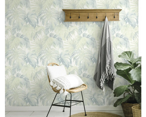 Decoratieve kamer met behang met bladerenmotief, kapstok en rotan stoel