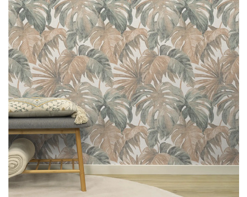 Kamer met een patroonbehang met tropische bladeren, een bank met kussen en een opgerolde deken.