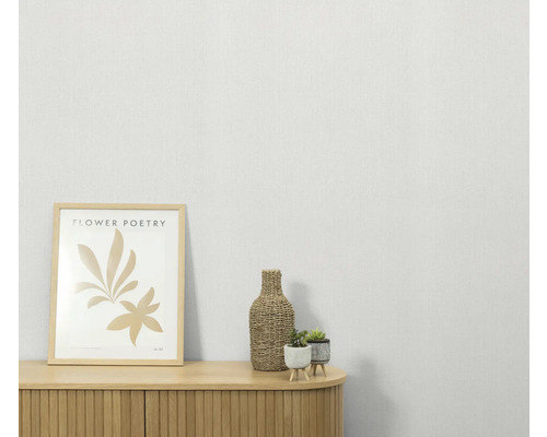 Decoratieve scène met een dressoir, een ingelijste afbeelding, een fles en potplanten.