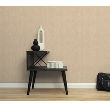 Scene met een gestructureerd behang, een bijzettafel met decoratieve items en een handtas.