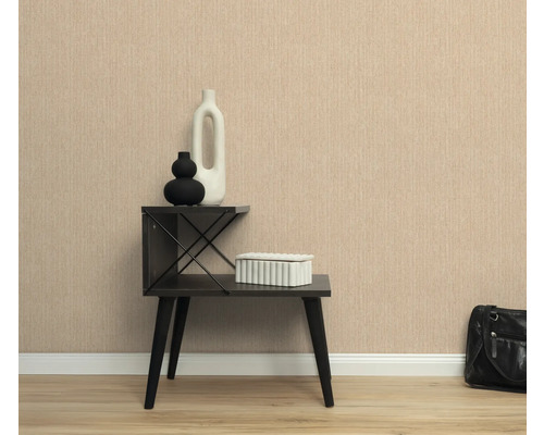 Scene met een gestructureerd behang, een bijzettafel met decoratieve items en een handtas.