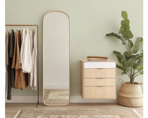 Kameroverzicht met kledingrek, spiegel, ladekast en plant