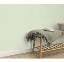 Lichtgekleurd behang op de muur, bank met deken en boeken