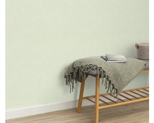 Lichtgekleurd behang op de muur, bank met deken en boeken